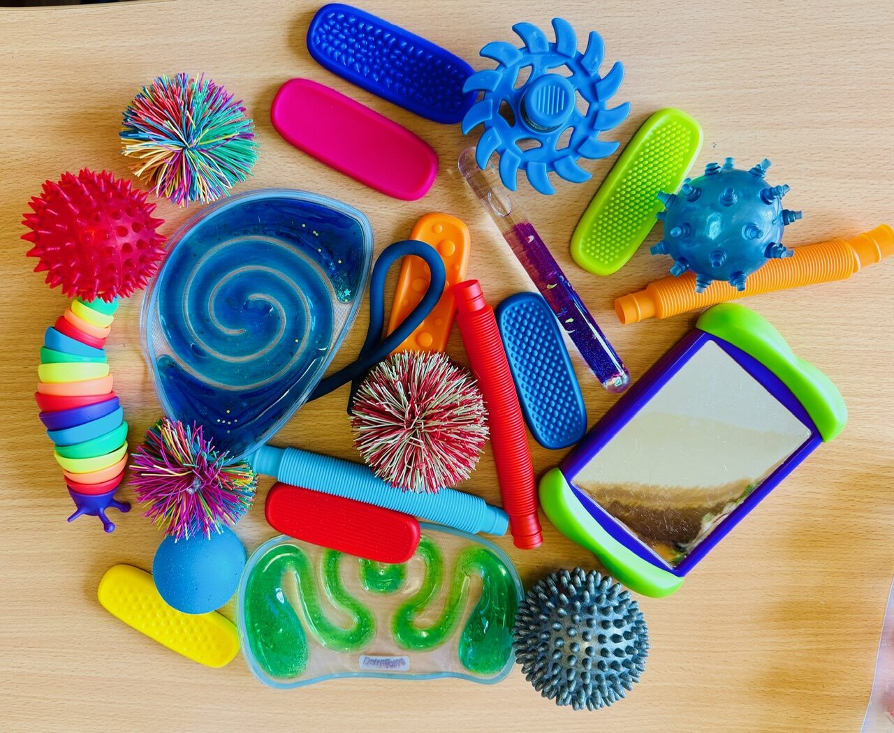 A collection of bright sensory and fidget toys laid out on a table